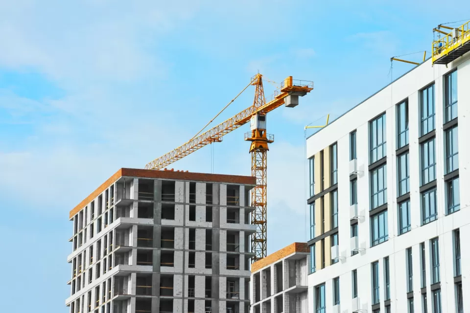 Apartment buildings under construction with crane.